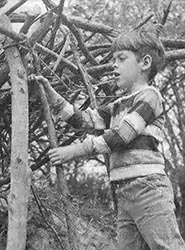 Our son Matthew constructs a log fort with deadwood scavenged from the nearby forest.